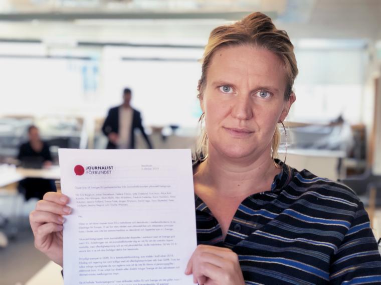 Hanna Nybergs, ordfröande Journalistförbudnets yttreandefrihetsgrupp, håller upp öppet brev till EU-parlamentariker 